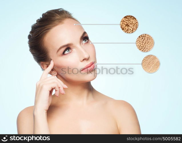 beauty, people and bodycare concept - beautiful young woman face with dry skin sample over blue background. beautiful young woman face with dry skin sample