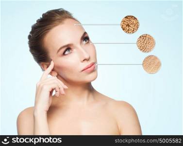 beauty, people and bodycare concept - beautiful young woman face with dry skin sample over blue background. beautiful young woman face with dry skin sample