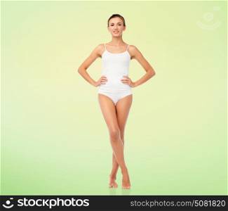 beauty, people and bodycare concept - beautiful young woman in white underwear over green natural background. beautiful young woman in white underwear