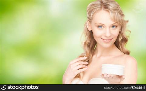 beauty, people and health concept - beautiful smiling woman cleaning face skin with cotton pad over green natural background