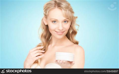 beauty, people and health concept - beautiful smiling woman cleaning face skin with cotton pad over blue background
