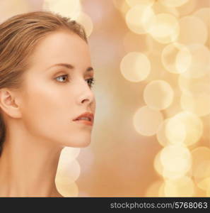 beauty, people and health concept - beautiful young woman face over beige lights background