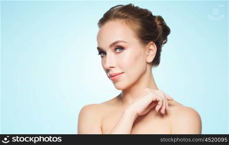 beauty, people and health concept - beautiful young woman face over blue background