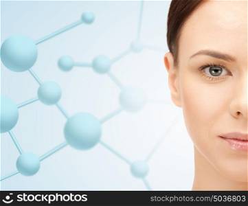 beauty, people and health concept - beautiful young woman face over blue background with molecules. close up of beautiful woman half face