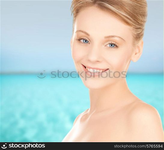 beauty, people and health concept - beautiful young woman face over blue sea and sky background