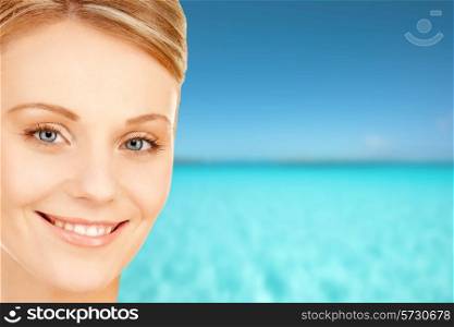 beauty, people and health concept - beautiful young woman face over blue sky and sea background