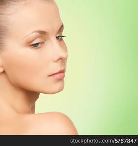 beauty, people and health concept - beautiful young woman face over green background