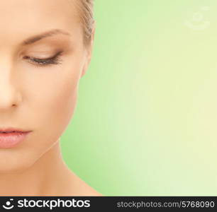 beauty, people and health concept - beautiful young woman face over green background