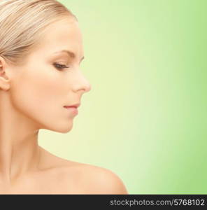 beauty, people and health concept - beautiful young woman face over green background