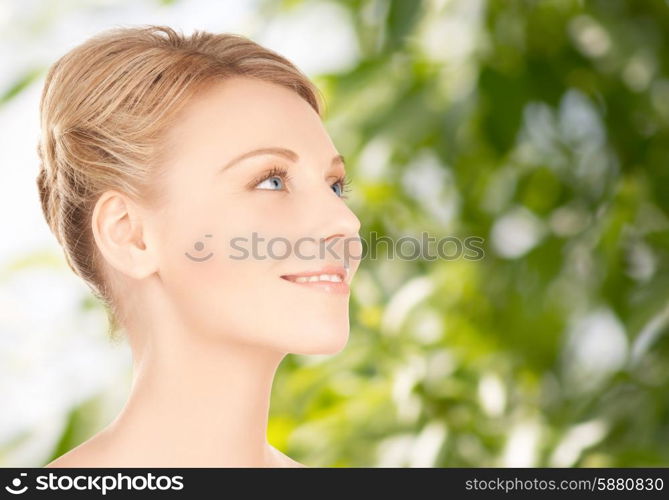 beauty, people and health concept - beautiful young woman face over green background