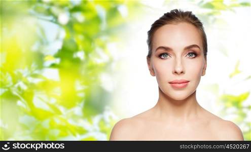 beauty, people and health concept - beautiful young woman face over green natural background
