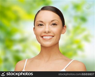 beauty, people and health concept - beautiful young woman face over green natural background. beautiful young woman face. beautiful young woman face