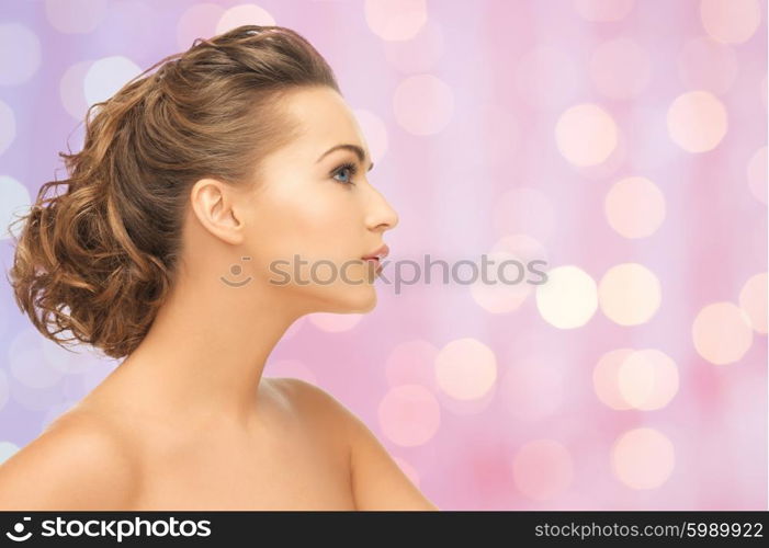 beauty, people and health concept - beautiful young woman face over pink background