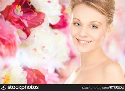 beauty, people and health concept - beautiful young woman face over pink floral background