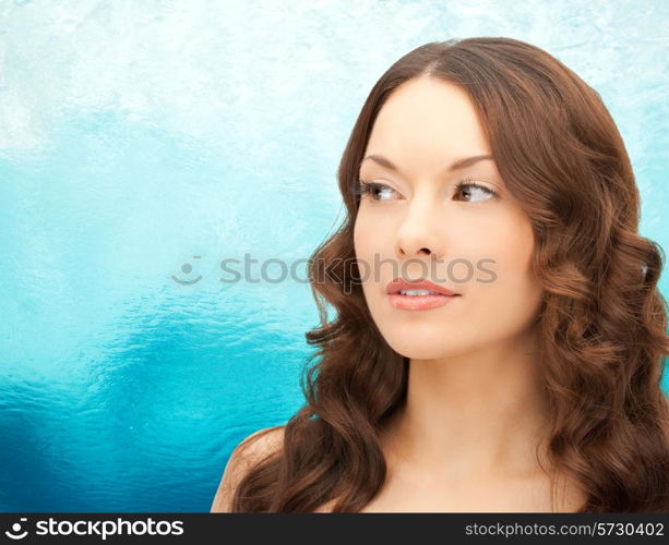 beauty, people and health concept - beautiful young woman face over ripple blue water background