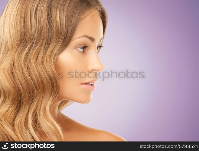 beauty, people and health concept - beautiful young woman face over violet background