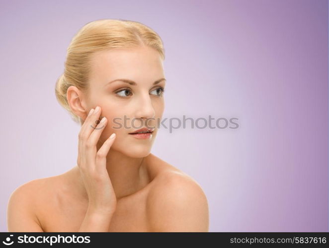 beauty, people and health concept - beautiful young woman face over violet background