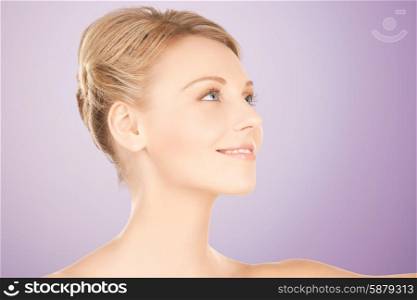 beauty, people and health concept - beautiful young woman face over violet background