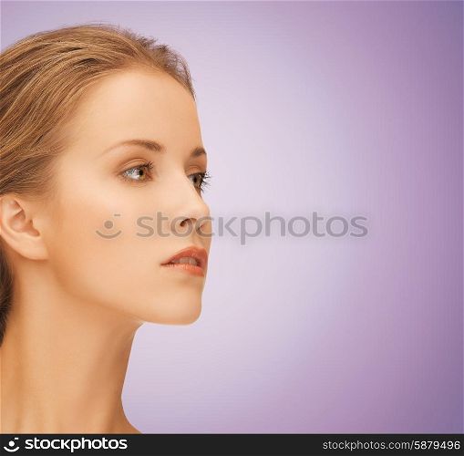 beauty, people and health concept - beautiful young woman face over violet background
