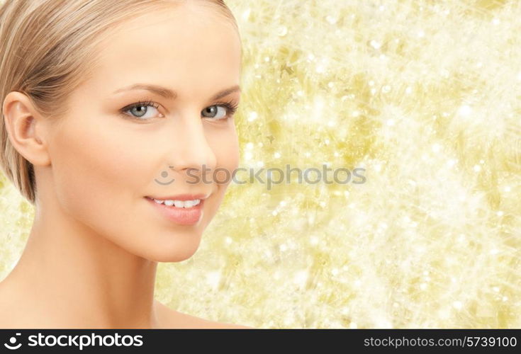 beauty, people and health concept - beautiful young woman face over yellow lights background