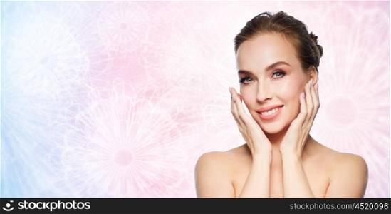 beauty, people and health concept - beautiful young woman touching her face over rose quartz and serenity patterned background