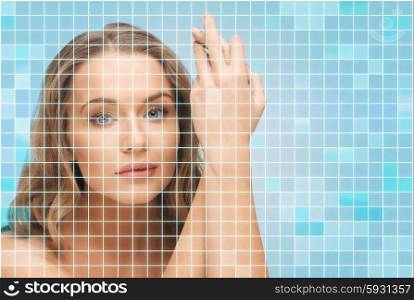 beauty, people and health concept - beautiful young woman touching her face and hands over pink background