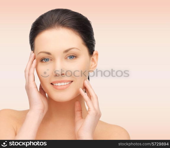 beauty, people and health concept - beautiful young woman touching her face over pink background