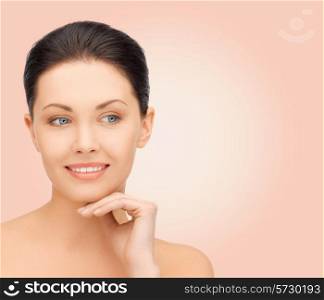 beauty, people and health concept - beautiful young woman touching her face over pink background