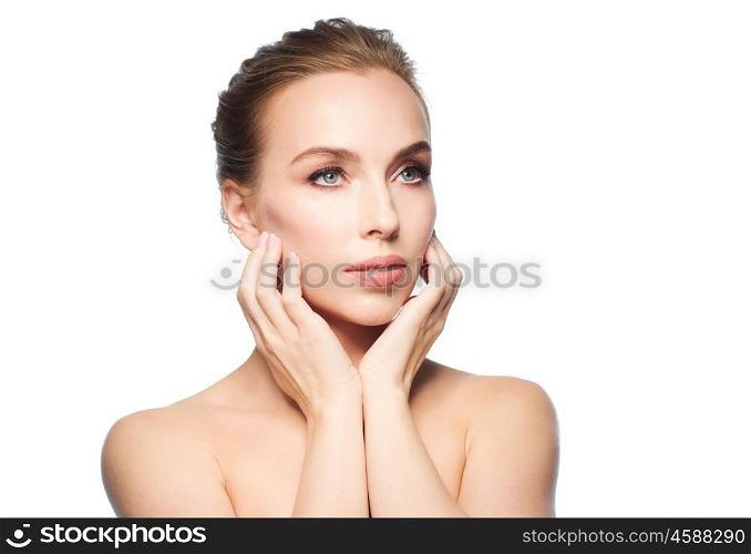 beauty, people and health concept - beautiful young woman touching her face over white background