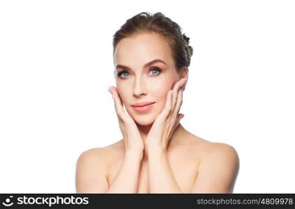 beauty, people and health concept - beautiful young woman touching her face over white background