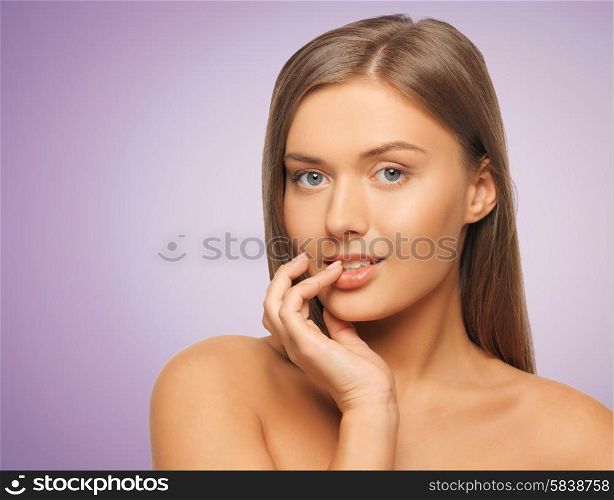 beauty, people and health concept - beautiful young woman touching her lips over violet background