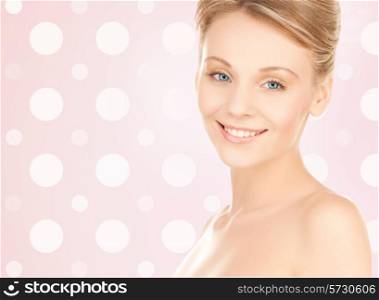beauty, people and health concept - beautiful young woman with bare shoulders over pink and white polka dots pattern background