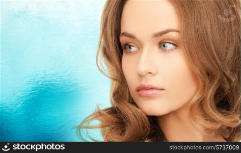 beauty, people and health concept - beautiful young woman with bare shoulders over blue ripple water background