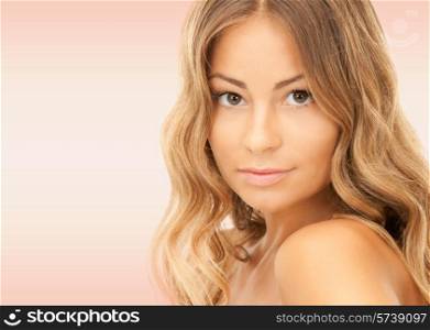 beauty, people and health concept - beautiful young woman with bare shoulders and long wavy hair over pink background