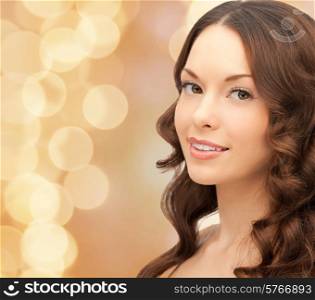 beauty, people and health concept - beautiful young woman with bare shoulders and long wavy hair over beige lights background