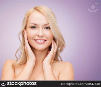 beauty, people and health concept - beautiful young woman with bare shoulders touching her face over violet background