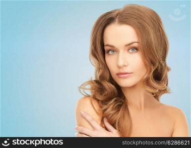 beauty, people and health concept - beautiful young woman with bare shoulders over blue background