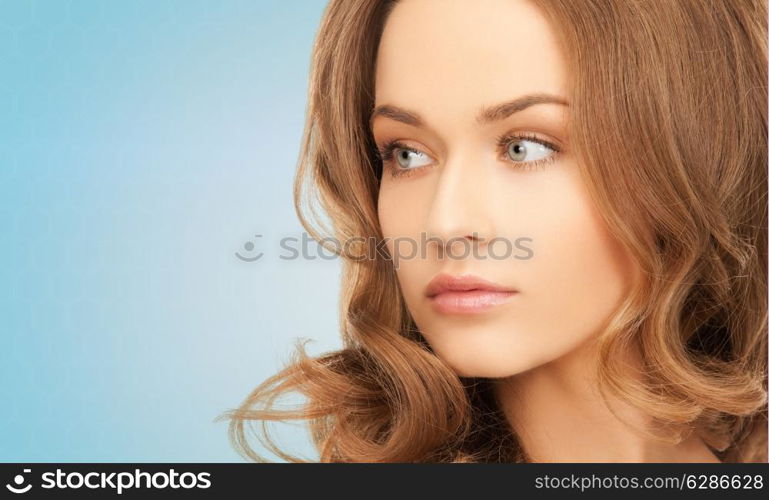 beauty, people and health concept - beautiful young woman with bare shoulders over blue background