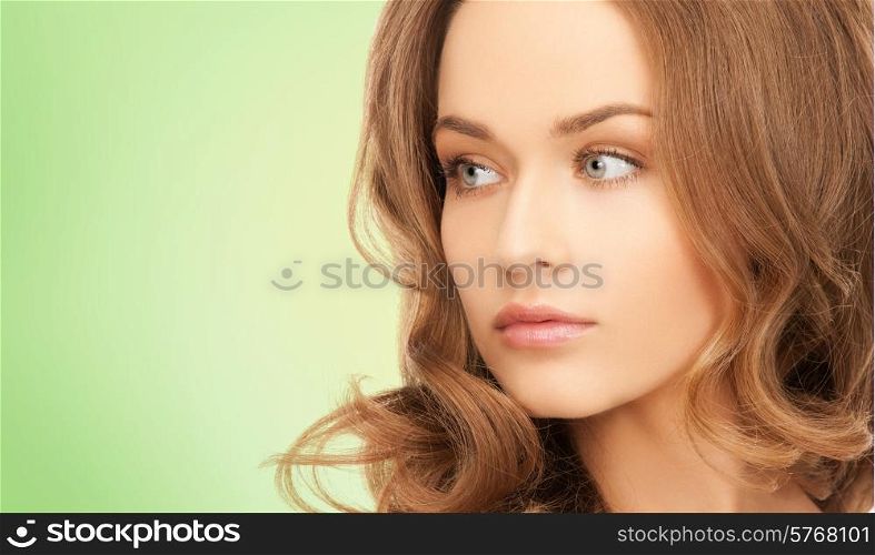 beauty, people and health concept - beautiful young woman with bare shoulders over green background