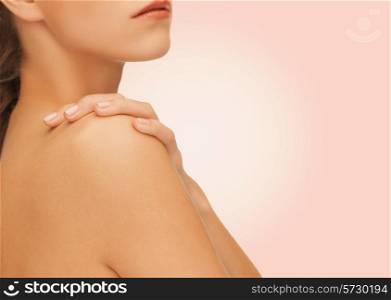 beauty, people and health concept - beautiful young woman with bare shoulders over pink background