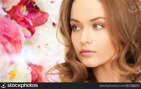 beauty, people and health concept - beautiful young woman with bare shoulders over pink floral background
