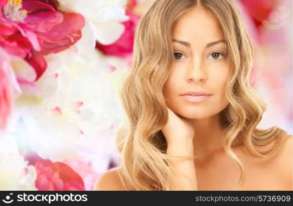 beauty, people and health concept - beautiful young woman with bare shoulders over pink floral background