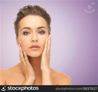 beauty, people and health concept - beautiful young woman with bare shoulders over violet background