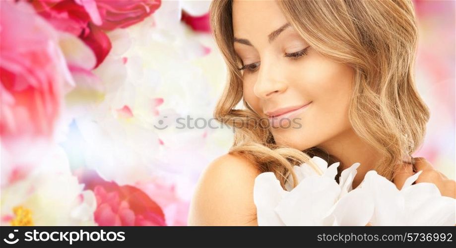 beauty, people and health concept - beautiful young woman with flowers and bare shoulders over pink floral background