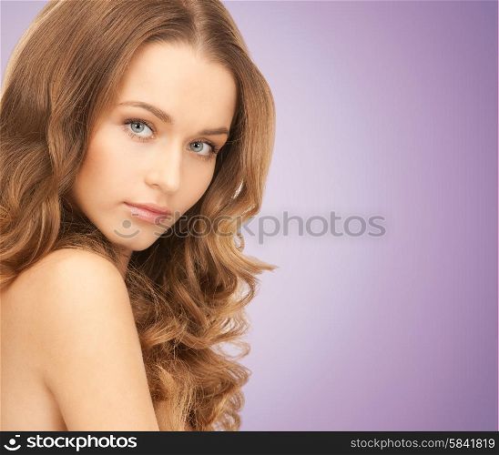 beauty, people and health concept - beautiful young woman with long wavy hair over violet background