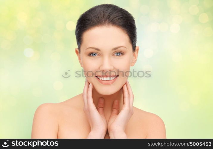 beauty, people and health concept - close up of beautiful young woman face over green lights background. close up of beautiful young woman face