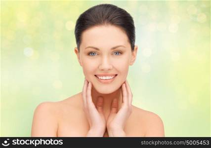 beauty, people and health concept - close up of beautiful young woman face over green lights background. close up of beautiful young woman face
