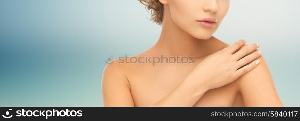 beauty, people and health concept - close up of beautiful young woman with bare shoulders over blue background