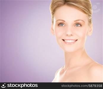beauty, people and health concept - close up of beautiful young woman face over violet background