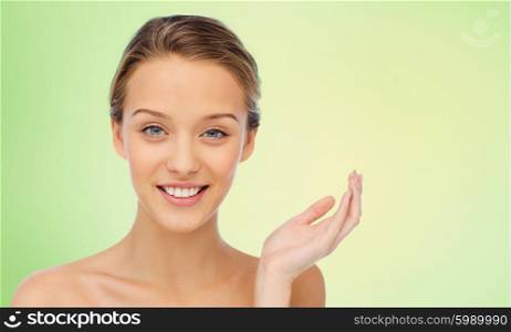 beauty, people and health concept - smiling young woman face and shoulders over green natural background